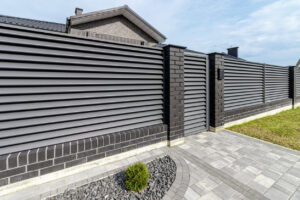 Fragment of a modern fence lined with decorative bricks in the old style.