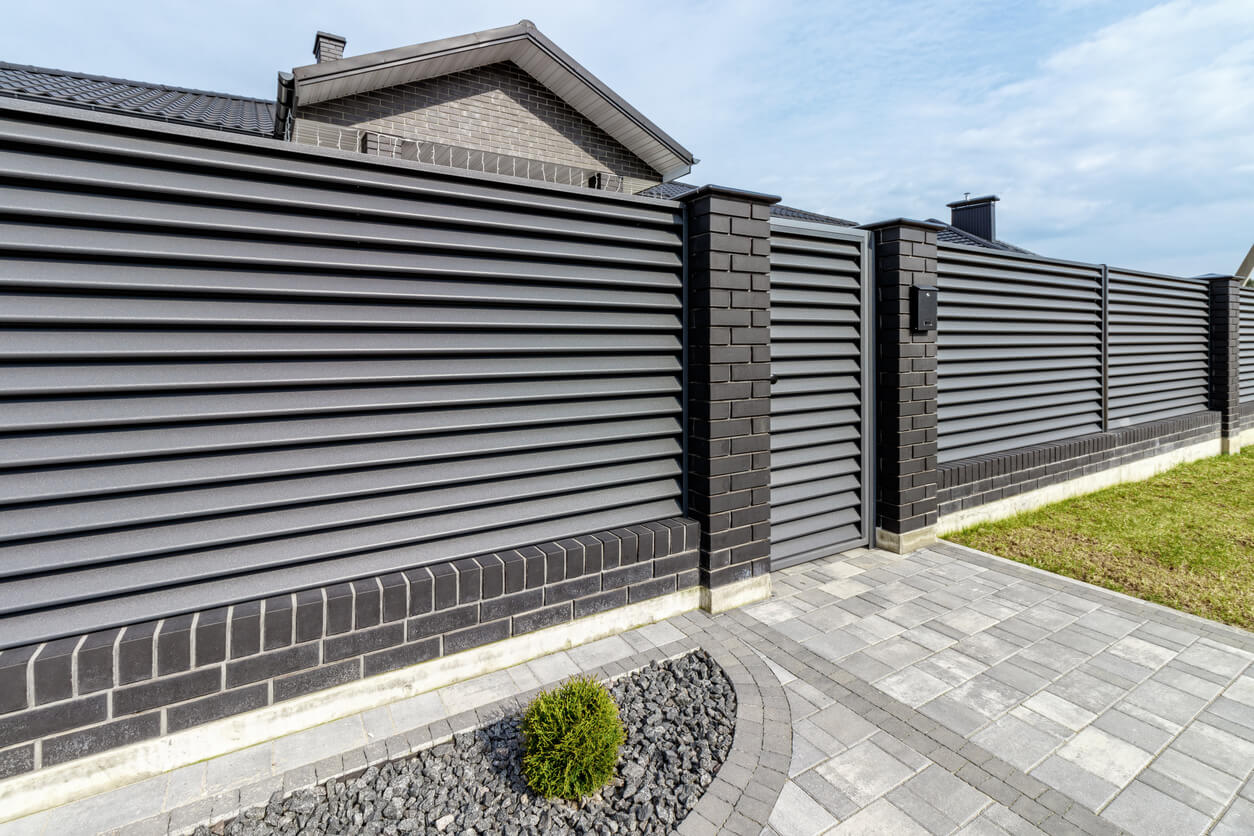 Fragment of a modern fence lined with decorative bricks in the old style.